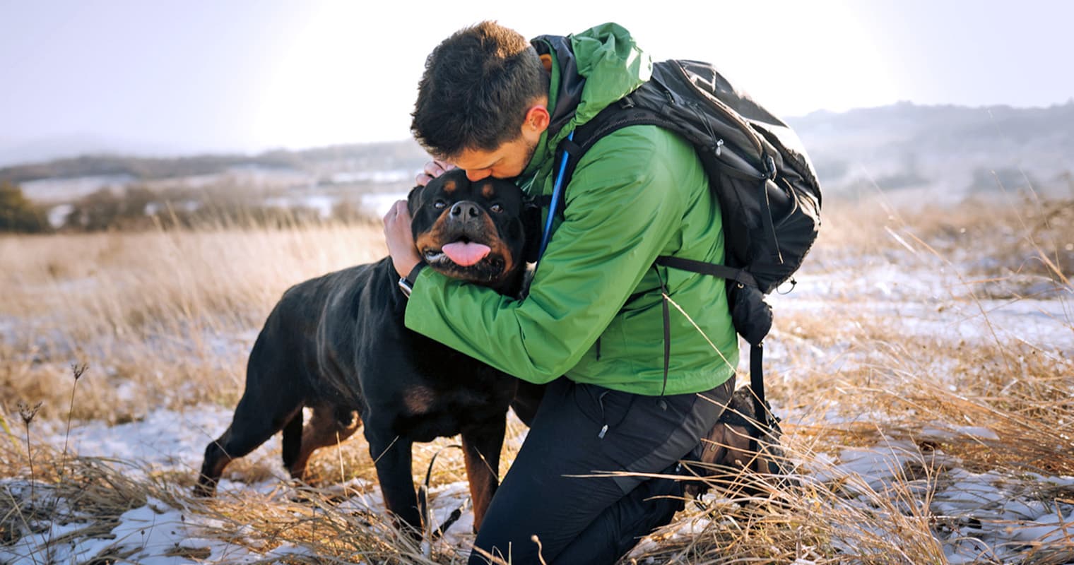 man hugging rottie