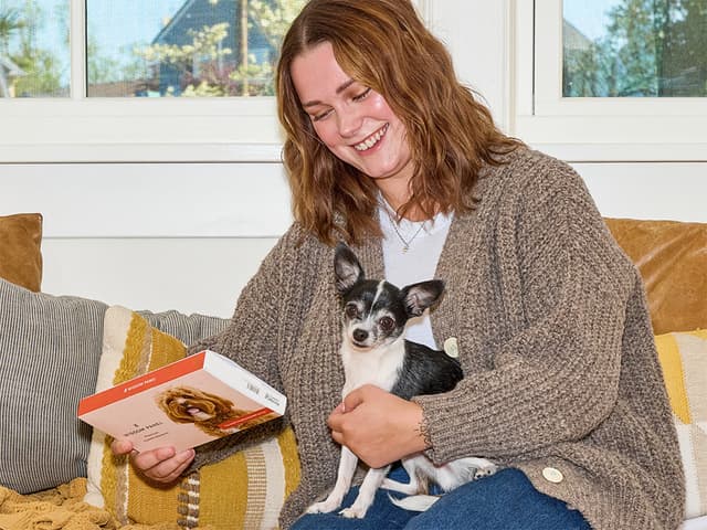 woman holding wisdom panel with chihuahua mix