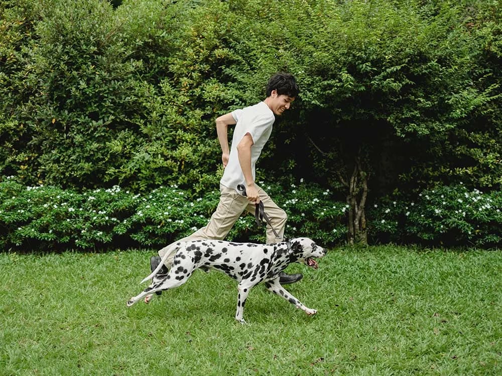 man running happily with his dog