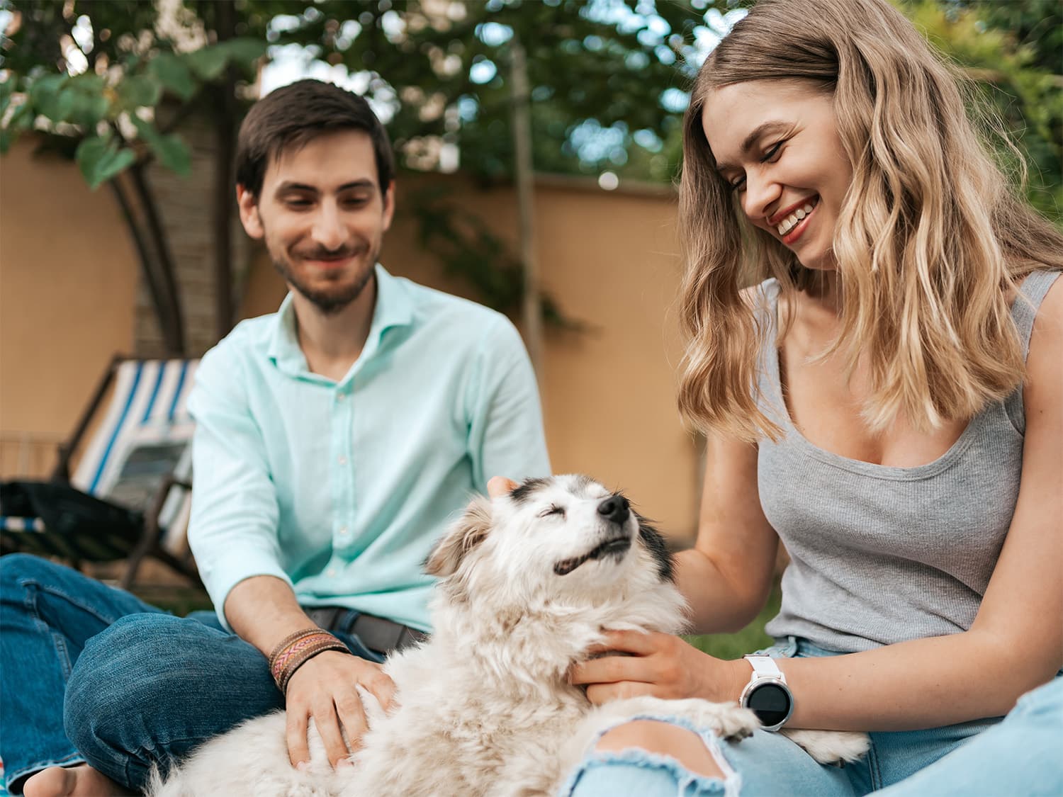 two people petting old dog