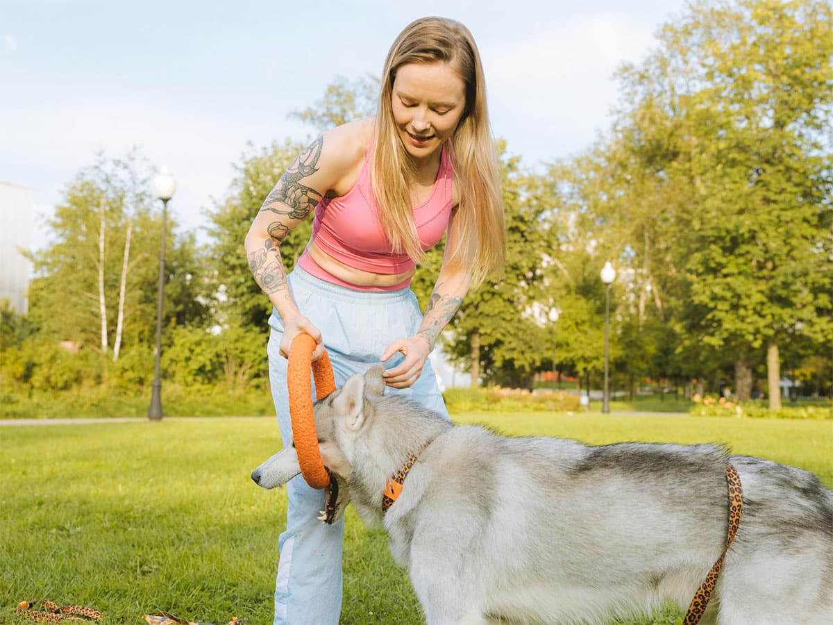 woman having hard time training husky
